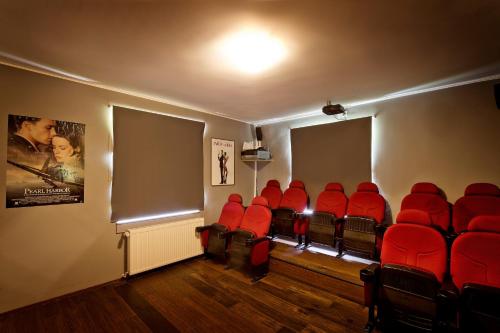 une salle d'attente avec des chaises rouges et une affiche de film dans l'établissement Tolles Ferienhaus für 16 Personen im Westerwald mit Sauna, Whirlpool, Kino und Bar, à Schutzbach