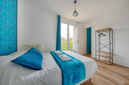 a bedroom with a bed with blue pillows and a window at Welcome to Blue Dream House in Marly-le-Roi