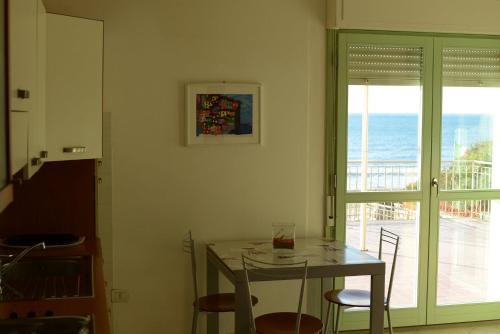 una sala da pranzo con tavolo e vista sull'oceano di Residence Onda Etrusca a San Vincenzo