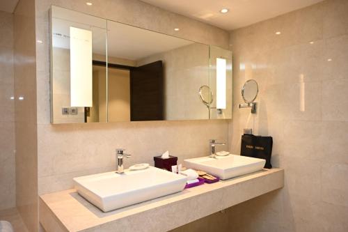 Baño con 2 lavabos y espejo en The LaLiT New Delhi, en Nueva Delhi