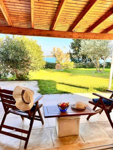 a patio with a table and a straw hat on it at SV Apartment with sea view in Gouvia