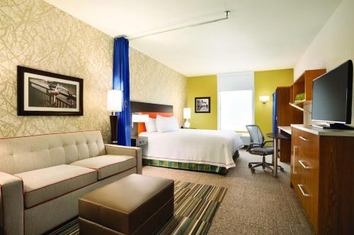 a hotel room with a bed and a couch at Home2 Suites By Hilton Birmingham Downtown in Birmingham