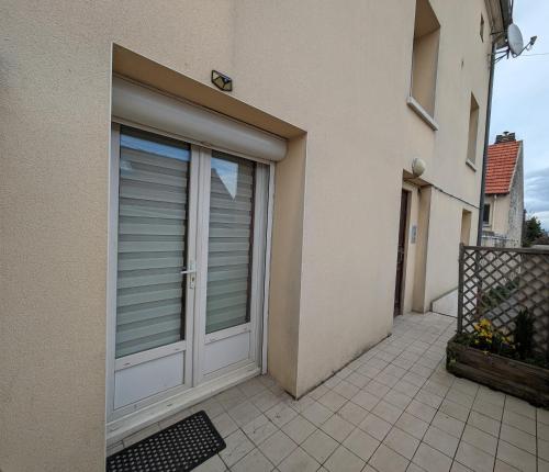 uma porta de garagem branca de uma casa em Arty Retro Appart - F2 proche de Disney em Nanteuil-lès-Meaux