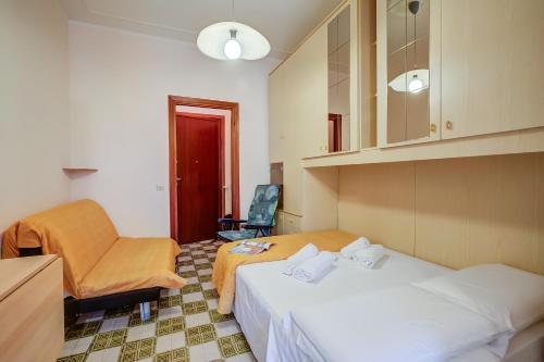 ein Hotelzimmer mit 2 Betten und einem Stuhl in der Unterkunft Il Rifugio - Town Center - Happy Rentals in Borghetto Santo Spirito