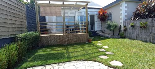 a backyard with a fence and a grass yard at Ti Bamboo in Le Tampon