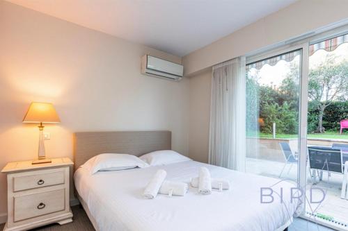 une chambre avec un lit et une grande fenêtre dans l'établissement Spacious apartment Pool and Parking, à Antibes