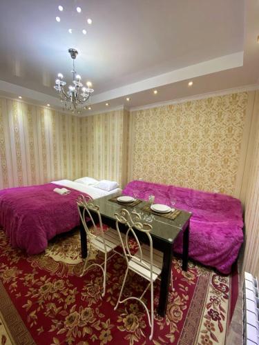 um quarto com uma cama, uma mesa e cadeiras em UrbanView Studio em Chisinau