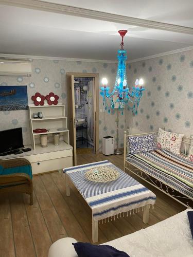 a living room with a bed and a chandelier at Olympus Miracle in Limani Litochorou