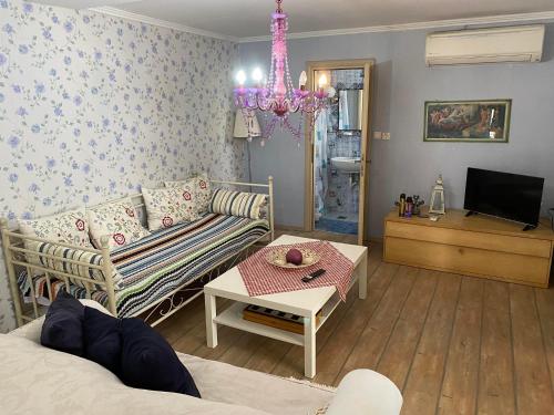 a living room with a couch and a chandelier at Olympus Miracle in Limani Litochorou