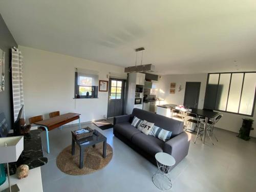 a living room with a couch and a table at Aux couleurs de la Baie à Sailly-Bray in Noyelles-sur-Mer