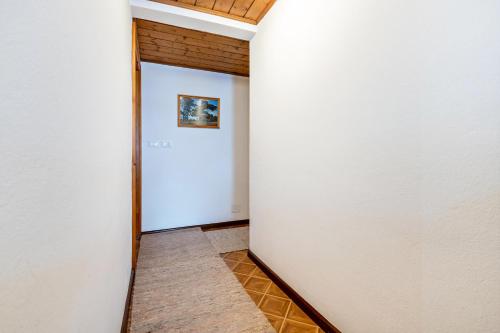 a hallway with a white wall and a picture on the wall at Samont Appartment 5 in Arabba