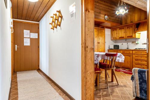 a hallway leading to a kitchen with wooden cabinets at Samont Appartment 5 in Arabba