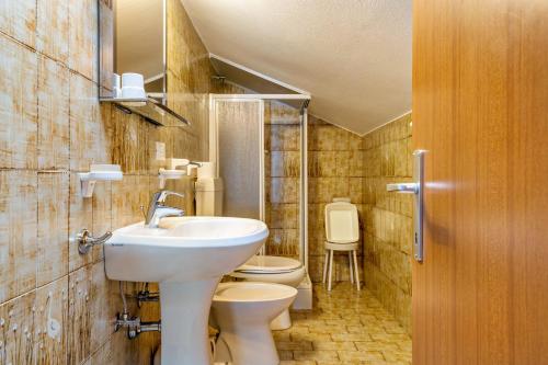 ein Bad mit einem Waschbecken und einem WC in der Unterkunft Samont Appartment 5 in Arabba