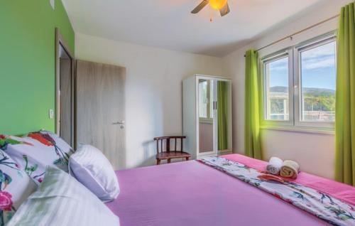 a bedroom with a large purple bed with a window at Holiday home Perunika in Žeževica