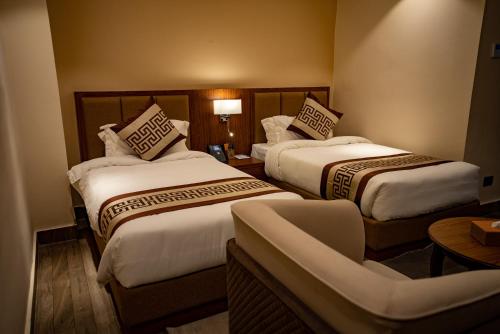 una habitación de hotel con 2 camas y una silla en Hotel Monalisa Kathmandu Pvt. Ltd, en Katmandú