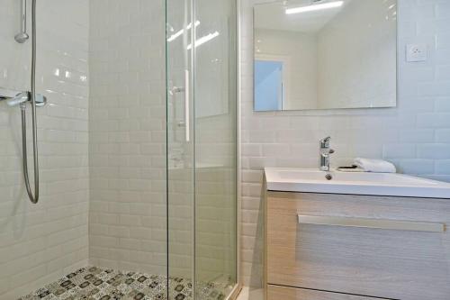 Un baño con lavabo y ducha de cristal. en Welcome to the green House, en Marly-le-Roi