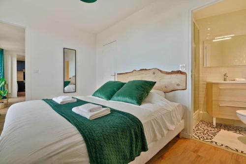 1 dormitorio con cama con almohadas verdes y lavamanos en Welcome to the green House, en Marly-le-Roi