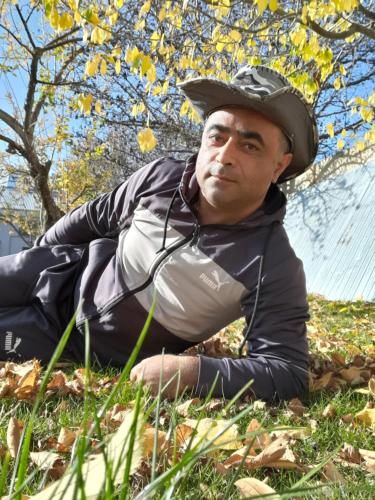 a man laying on the grass with a hat at Spartak in Sisian
