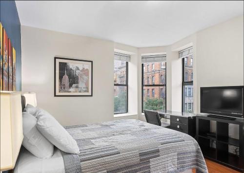 a bedroom with a bed and a flat screen tv at Comfortable Studio in Prime Location in New York