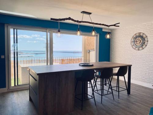 Una cocina con una gran isla con vista al mar. en Panoramic - Magnifique T3, Climatisé avec Parking, en Sète