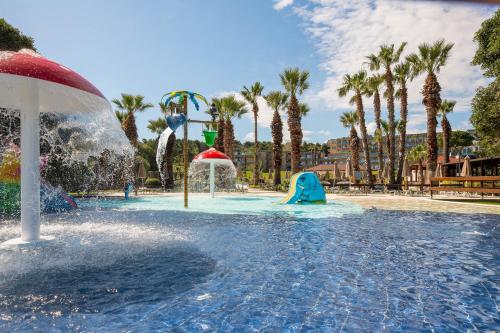 a pool with a water park with palm trees at Kresten Palace Hotel in Kallithea Rhodes