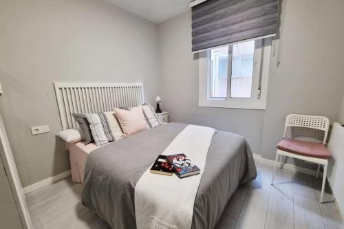ein Schlafzimmer mit einem Bett, einem Stuhl und einem Fenster in der Unterkunft VibesCoruña - Ángel 72 in A Coruña