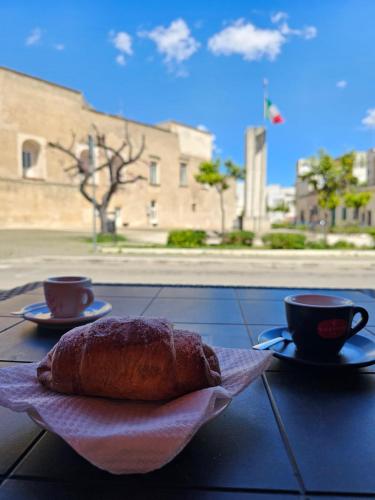 een brood zittend op een tafel met twee kopjes bij B&b Ètoile Salento in Arnesano