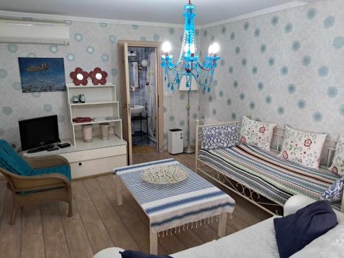 a living room with a couch and a chandelier at Olympus Miracle in Limani Litochorou