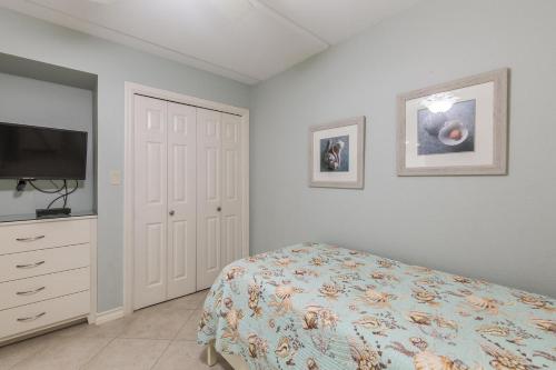 a bedroom with a bed and a flat screen tv at Surfside II #109 home in Coffeyville