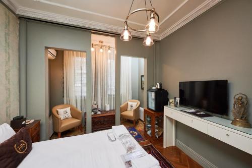 a living room with a bed and a flat screen tv at Faik Pasha Hotels Special Category Beyoglu Istanbul in Istanbul