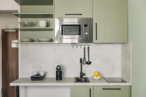 a kitchen with green cabinets and a counter top at Homaris Apartments Frankfurt in Frankfurt/Main