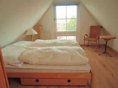 a bed with a white comforter in a room at Ferienwohnung Frische Brise in Drewoldke