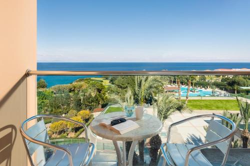 a table and chairs on a balcony with a view of the ocean at Kresten Palace Hotel in Kallithea Rhodes