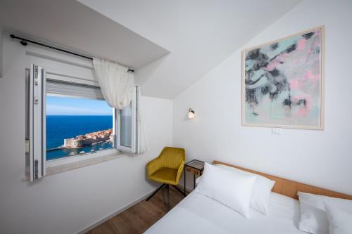 a bedroom with a window with a view of the ocean at Apartments Mariana in Dubrovnik