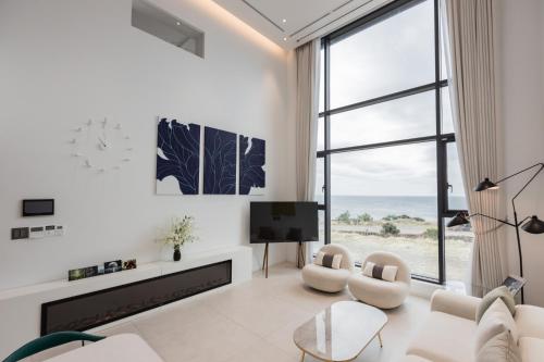 a living room with white furniture and a large window at B202 OceanView 돌고래출몰 수영장 노래방 스크린골프 in Seogwipo