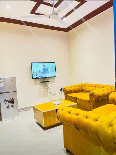 a living room with two couches and a flat screen tv at Guest Bakhita in Abomey-Calavi