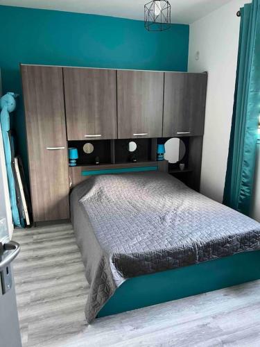 une chambre avec un grand lit avec un mur bleu dans l'établissement Maison charmante à San-Nicolao 55 m² avec piscine partagée, à San-Nicolao