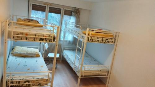 une chambre avec trois lits superposés et une fenêtre dans l'établissement TONY House, à Bondy