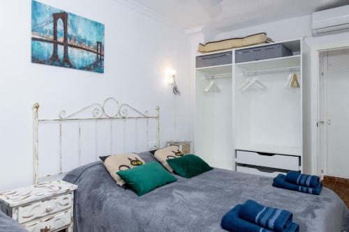 sypialnia z łóżkiem z zielonymi i niebieskimi poduszkami w obiekcie ESPANATOUR ALMORADI 7 w mieście Torrevieja
