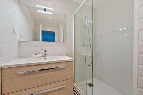 Un baño con lavabo y ducha con espejo. en Welcome To The Lola House, en Marly-le-Roi
