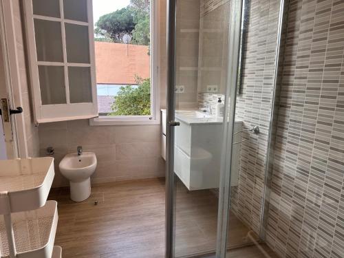 a bathroom with a toilet and a sink and a shower at Casa única con jardín a 45 metros de la playa. BE in Palamós