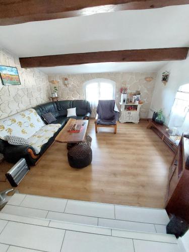 un salon avec un canapé et une table dans l'établissement Maison de charme à Autignac avec vue sur jardin et montagne, à Autignac