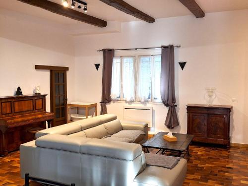 uma sala de estar com um sofá e um piano em Maison de 2 chambres avec piscine partagee jardin clos et wifi a Avignon em Avignon