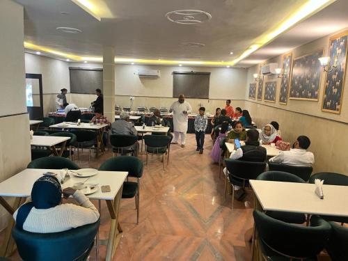 un grupo de personas sentadas en mesas en un restaurante en The Amur Falcon Inn & Resorts en Rāja Sānsi