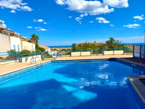 une piscine avec vue sur l'océan dans l'établissement Plain-pied Jardin 6 personnes Clim Vue Mer Parking Wifi Terrasse Piscine dans la résidence, à Saint Pierre La Mer