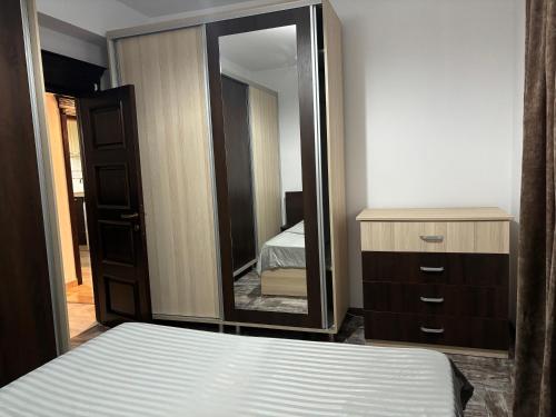 1 dormitorio con cama y espejo grande en Sweet Home Iasi Airport 2 en Iaşi