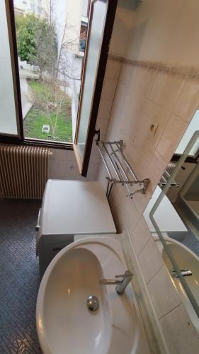 une salle de bain avec toilettes, lavabo et fenêtre dans l'établissement TONY House, à Bondy