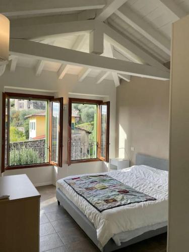 a bedroom with a bed and two windows at La dolce vita al lago in Bogliaco