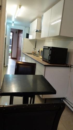 une cuisine avec une table et des chaises et un micro-ondes dans l'établissement TONY House, à Bondy