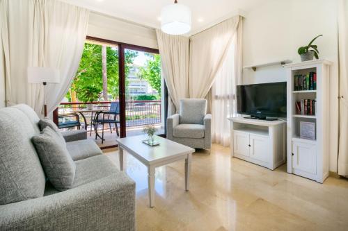 a living room with a couch and a tv and a table at Apartamentos Albir Confort - Avenida 1 dorm in Albir